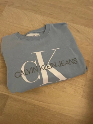 Tröja Calvin Klein Jeans - Ljusblå tröja från Calvin Klein, storlek S, sparsamt använd.