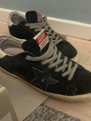 Mörkblå Golden goose Superstar sneakers - Mörkblåa Golden Goose Superstar sneakers i mocka. Märket GGDB syns på plösen och insidan. Klassisk låg modell med vintage-inspirerad look och kontrastfärgade detaljer. Skriv för minsta lilla! Dustbags och box och sånt finns! 