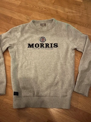 Grå tröja från Morris - Snygg grå stickad tröja från Morris i storlek M. Tröjan har rund halsringning, ribbade muddar och nederkant. Perfekt för dig som gillar klassisk stil med en modern twist.