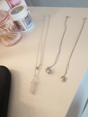 Tre silverfärgade halsband med hängen - Säljer tre snygga halsband i silverfärg. 
