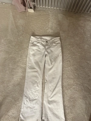 Vita bootcut jeans från Cheap Monday - Säljer ett par vita bootcut jeans från Cheap Monday med klassisk femficksmodell och logga på bakfickan. Jeansen har låg midja och är tillverkade i ett stretchigt bomullsmaterial. Perfekta för dig som gillar en clean och trendig look.