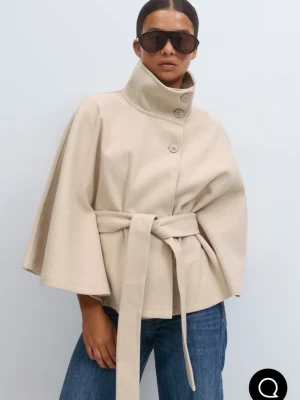 Beige cape-kappa med bälte - Stilren beige cape-kappa med hög krage, knäppning framtill och knytskärp i midjan. Vida ärmar och mjukt material ger en cool och avslappnad look. Perfekt för lager-på-lager och snygg till jeans.