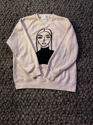 Söt ljusrosa college tröja, storlek 164 🩷🩷🩷🩷 - Cool rosa college tröja från Zara med ett stort grafiskt tryck av ett ansikte på framsidan. Tröjan har rund halsringning, långa ärmar och ribbade muddar. Perfekt för en avslappnad och trendig look.🤩🤩🤩