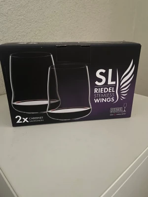 Riedel Stemless Wings vinglas 2-pack - Två stilrena vinglas från Riedel, modell Stemless Wings Cabernet Sauvignon. Glasen är genomskinliga, utan fot och har en modern, rundad form som gör dem perfekta för vin. Levereras i originalförpackning.