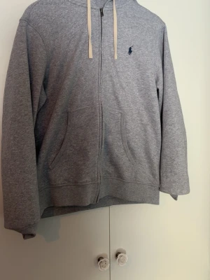 Grå zip hoodie från Polo Ralph Lauren - En grå zip hoodie från polo raulph Lauren. Storlek M. Mycket bra skick skriv om ni har frågor. 