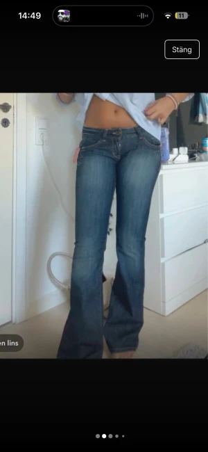 Blå bootcut jeans från Guess - Säljer ett par snygga blå jeans från Guess med bootcut passform och låg midja. Jeansen har klassiska fickor med dekorativa sömmar. Materialet är jeans med en mörk tvätt och slitningar framtill.