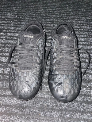 Puma fotbollsskor - Svarta fotbollsskor från Puma med cool design. De är inte så mycket använda, har dobbar och är i storlek 35. 