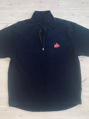 Golf vindtröja från Samling - Salming golf vindtröja i stretch är gjord av ett tunt, vindtätt tyg i polyester. ½ dragkedja fram. Dragsko nertill på kroppen. Börje Salmings signatur och lönnlövet (Kanadas symbol) på bröstet.