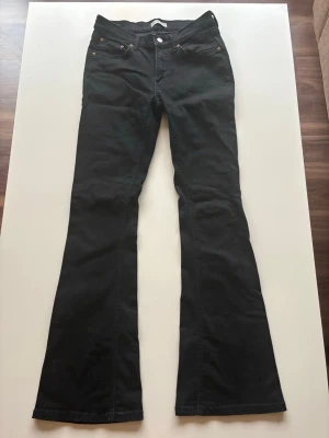 Svarta bootcut-jeans från Gina  - Svarta lowrise-bootcut jeans från Gina tricot (perfect jeans) i storlek 38. Väldigt snygga och sköna, men är knappt använda då de är för korta för mig!