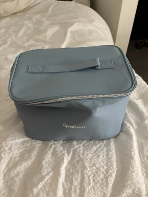 Ljusblå necessärväska från Apohem - Säljer en ljusblå stor necessärväska från Apohem med praktiskt handtag på locket och dragkedja runt om. Väskan är rymlig och har ett stilrent, enkelt utseende. Materialet är syntet och insidan är ljusgrå. Perfekt för att organisera dina grejer.