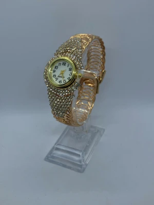 En elegant damklocka med strassdetaljer - KÖP 2 FÅ 1 PRESENT 🎁 Nytt batteri! 🔋   En elegant damklocka med strassdetaljer. Klockan har ett quartz urverk och ett vackert armband. Perfekt för speciella tillfällen eller för att piffa upp vardagslooken.  Skickar inom 24 timmar  Kvalitets kontroll  Säker parkering   Klockhållaren kommer inte med i köpet!