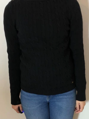 Kabelstickad tröja Ralph Lauren - Svart kabelstickad tröja i bomull. Stretchig och mycket skön att ha på sig ! Mycket fint skick, ingenting att anmärka på.  Bröstvidd: 48 cm Midjevidd: 45 cm Total längd: 61 cm