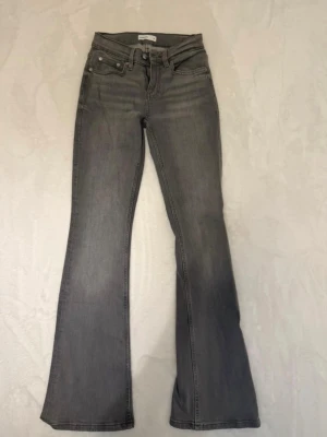 Grå bootcut jeans från Gina Tricot - Snygga grå jeans från Gina Trucot i bootcut-modell i storlek 32. Jeansen är helt oanvända och pris kan diskuteras 