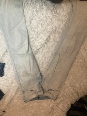 Ljusgrå jeans med raka ben - Snygga ljusgrå jeans med raka ben och klassiska fickor bak med knappstängning. Jeansen har en enkel design och är tillverkade i mjukt denimtyg som ger en skön känsla. Passar dig som gillar stilrena och ljusa jeans med normal passform.