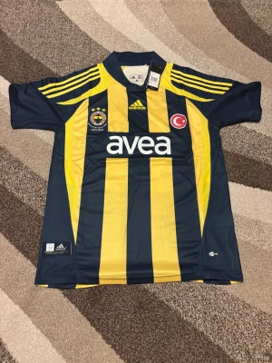 Fenerbahce Retro 07-08 Hemmatröja - Denna Fenerbahce Retro 07-08 Hemmatröja är helt ny och aldrig använd. Den är i Storlek M och är perfekt passform. Den har Alex 10 på ryggen för den brasilianska spelaren Alexsandro de Souza. Skit snygg tröja och skön att ha. Vid frågor är det bara att skriva.