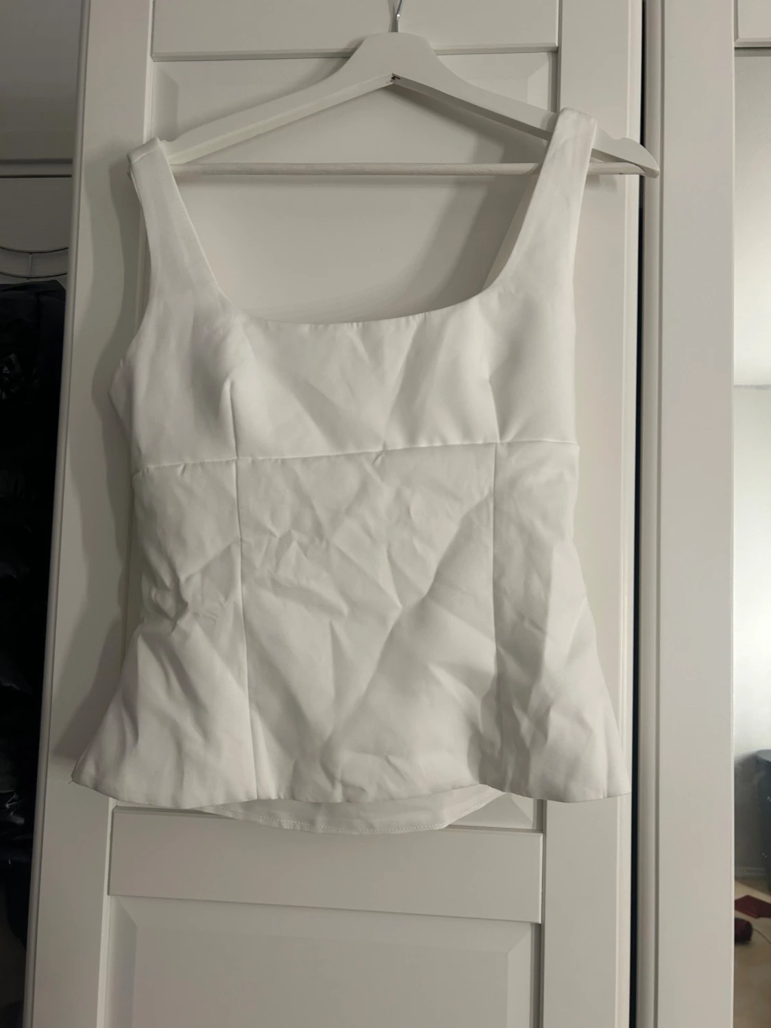 Vit linnetopp med rosett och öppen rygg