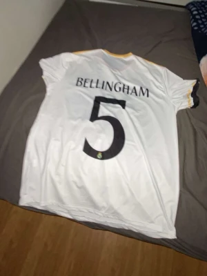 Real Madrid tröja - Bilden visar en vit fotbollströja med namnet Bellingham och nummer 5,