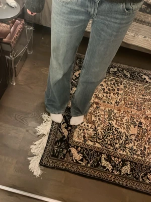 Low waist wide leg jeans från Zara - Säljer dessa trendiga ljusblå jeans från Zara med tvättad look och raka, breda ben med låg midja. Jeansen passar mig i längd och skulle därför säga att de passar någon som är runt 170-176 cm beroende på hur långa man vill ha dem. De är endast använda vid 2 tillfällen och är i väldigt bra till nytt skick, därav priset då jag köpte de för 400kr. Perfekt för dig som gillar en avslappnad och trendig look. Bilderna 5 och 6 är samma modell men i en annan färg.