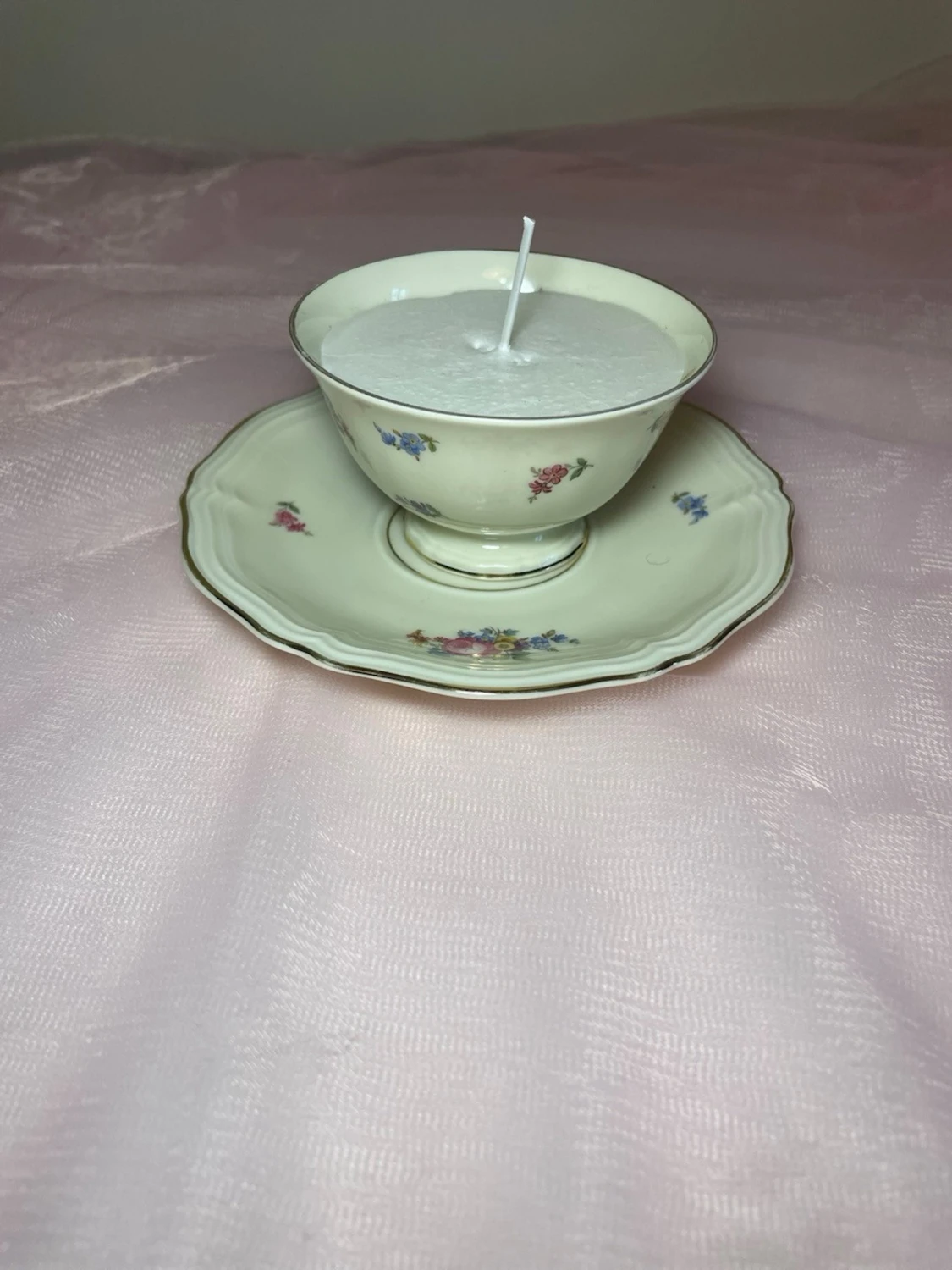 Doftljus i en tekopp med en vit kräm färgad flerfägsblommig design, nr 1 - 1