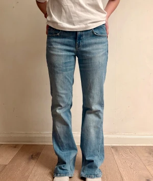ljusblå bootcut/baggy jeans - Innerbenslängd: 81 cm                              Midjemått: 35 cm                                       Grenlängd: 21 cm                                    Benöppning: 23 cm                                          Tecken på slitage vid benöppningen