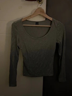 Grå långärmad topp från SHEIN - En enkel och stilren grå långärmad topp från SHEIN i storlek Petite XXS. Toppen har rund halsringning och är figurnära i modellen, perfekt att matcha med jeans eller kjol. Materialet känns mjukt och lätt mot huden.