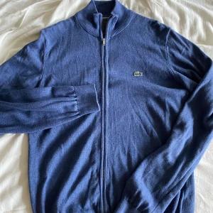 Lacoste zip - Tröjan är i fint skick och helt utan defekter förutom att lappen är bortklippt. På bilderna ser tyget mer slitet än vad det faktiskt är. Pris är absolut diskuterbart och kontakta mig om frågor!😊🐊