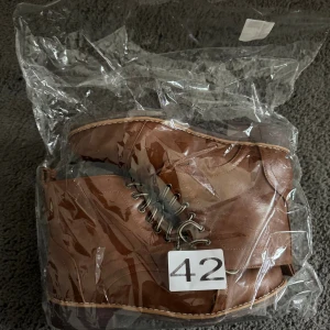 Bruna boots med snörning - Snygga bruna boots i skinnimitation med rund tå och snörning. Sulan har ett blommönster undertill och skorna har sömmar längs kanterna. Oanvända bara upplockade ur påsen💕