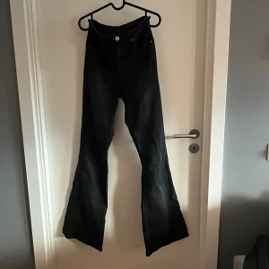 Svarta super high flare jeans från Lee - Svarta jeans med superhög midja och riktigt utsvängda ben, så kallad flare-modell från Lee. Materialet är klassiskt jeans och färgen är helsvart.