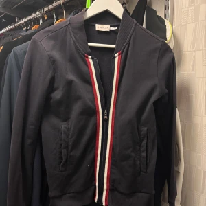 Moncler maglia zip tröja - Säljer en blå moncler maglia zip tröja utan luva. Den är i fint skick och har inga fläckar eller hål. Storlek S. Priset är ej hugget i sten! 