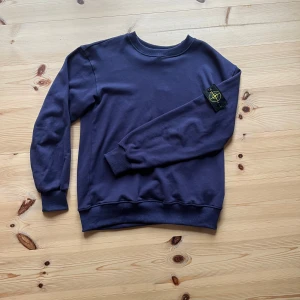 Mörkblå sweatshirt från Stone Island - Snygg mörkblå sweatshirt från Stone Island i bomull med klassisk rund hals och ribbade muddar. Den är riktigt stilig och passar till det mesta! Hör av dig vid frågor😀 mvh Ivan 