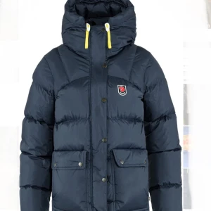 Mörkblå dunjacka från Fjällräven - Säljer min mörkblåa dunjacka från Expedition Down Lite Jacket: med huva och gula snören. Jackan har stora fickor framtill, knappar och dragkedja. Köpt för några årsen men är knappt använd, jag skulle säga nyskick! Den är helt perfekt för kalla vinterdagar! Den är i XXXS vilket motsvarar xs nu. Men passar S lika bra! 