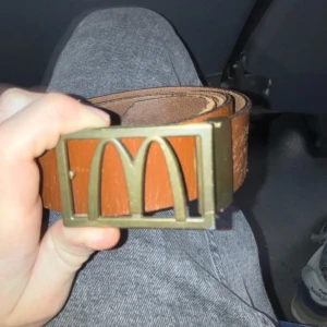 Brunt McDonalds skärp - Säljer ett brunt bälte från McDonalds med guldig buckla pris kan diskuteras 