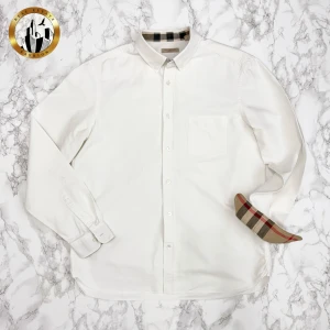 Burberry Skjorta L - Vit Burberry skjorta i storlek L i mycket bra skick förutom fläckarna på ärmen som syns på bild 2. Efter en tvätt var nästan fläckarna helt borta. Har därmed svårt att tro att de inte går att få bort om man så vill. Skjortan är självklart äkta. Är du osäker på äkthet hänvisar jag gärna till bra källor/guider. Tveka inte på att höra av dig för fler frågor eller vid minsta fundering! Skick: 9,5/10 (exklusive defekt)