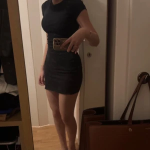 Svart tight kortklänning - Svart kortklänning från Bik Bok med rund hals och korta ärmar. Klänningen har en tight passform som framhäver figuren och är tillverkad i mjukt stretchigt material för en bekväm känsla. Perfekt för dig som gillar en enkel och stilren look.