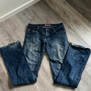 Blå Lestand jeans  - Säljer ett par blå vintage jeans från Lestand som inte säljs längre. Färgen är snyggt tvättad blå med ljusare partier. Knappen är lös men går enkelt att sy fast, även slitningar vid benens slut (se bild). Lite osäker på storlek men passar mig perfekt som brukar ha S och är 169cm lång. Hör gärna av er vid frågor!  
