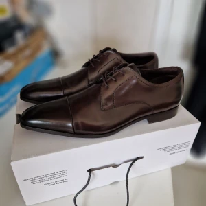 Oanvända Läder skor Storlek 44 - Helt nya i premium läder. Storlek 44 Ord.pris ca 2450 kr. Mjuk vadderad innersula i läder. Skickas spårbart i en annan låda. OBS: Inga byten eller returer