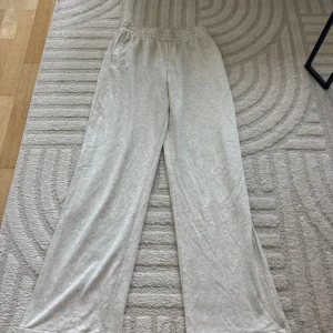 Gråa  mjukisbyxor från H&M XS - Superbekväma gråa  mjukisbyxor från H&M i storlek XS. De har elastisk midja och ett loose fit med raka, vida ben. Perfekta för chill dagar hemma eller när du vill ha en avslappnad stil. Materialet är mjukt och skönt mot huden.