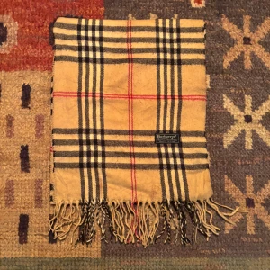 Vintage Burberry halsduk  - -Riktigt bra skick. Nypris på dessa ligger på runt 5000kr, vilket gör detta till ett sjukt bra pris! Halsduken är gjord i Lamull, och är perfekt inför hösten och den kommande vintern. Anledningen till att det står ”Burberry’s” och inte ”Burberry” på lappen är eftersom halsduken är från några år tillbaka, innan de bytte namn! Om du har någon fråga är det bara att skriva till mig. /elgnce (5)