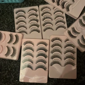 30 STYCKEN LÖS FRANSAR - Säljer flera paket med svarta lösögonfransar i olika stilar. Fransarna är täta och fluffiga, perfekta för att skapa en dramatisk look. Kommer i vita plastförpackningar med flera par i varje. Superenkla att applicera och ger en snygg volym.