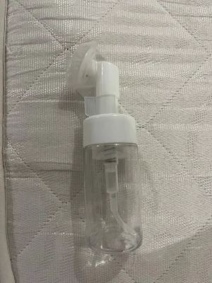 Transparent face mist-flaska med borste - Säljer en transparent face mist-flaska med vit pump och inbyggd mjuk borste på toppen. Funkar jättebra för din cleanser! Flaskan är gjord av plast och har ett lock som skyddar borsten. Perfekt för att applicera ansiktsmist eller toner på ett smidigt sätt.