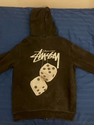 Stussy zip up hoodie (L) - Om du letar efter en snygg dragkedja med huvtröja behöver du inte leta längre. Detta är en autentisk Stussy-huvtröja helt i svart med vita tärningar. Storleken är L, så om du är 180+ cm lång kommer den här troligtvis att passa dig.