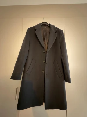 Svart rock med klassisk krage - Stilren svart rock från Zara med klassisk krage och tre knappar framtill. Jackan har två snedställda fickor och är helfodrad för extra komfort. Perfekt för dig som vill ha en tidlös och snygg look under höst och vinter. Använd endast en gång. S men passar även M.