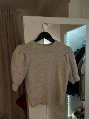 Beige kortärmad stickad tröja från Gina Young - Säljer en beige kortärmad stickad tröja med " puff ärmar " från Gina Young. Använd väldigt lite. 