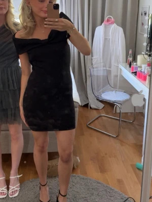 Svart offshoulder kortklänning - Snygg svart kortklänning med offshoulder-design och figurnära passform. Klänningen har en stilren och enkel look som passar perfekt när du vill känna dig extra fin. Materialet känns mjukt och följsamt mot kroppen. Storleken är L men sitter absolut inte så utan mer som m och jag brukar kunna ha s och m. Använd 1 gång 