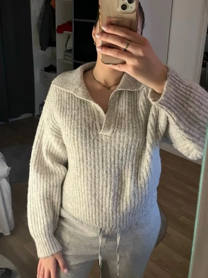 Grå stickad polotröja med krage - Säljer en grå stickad tröja från Gina tricot med bred krage och ribbad struktur.