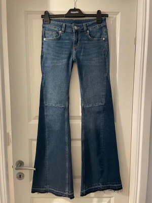 Blå bootcut jeans från H&M Divided - Säljer ett par blå bootcut jeans från H&M Divided i storlek 32. Jeansen är ultra low rised. Jag har spretat upp längst ner för att jag ville ha de lite längre. Har använt 2 gånger