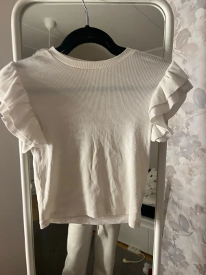 En volang tröja - En fin vit tröja med lite defekt på användning