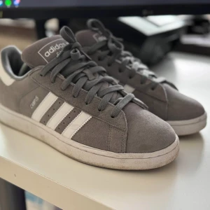Grå Adidas Campus 2 - Endast använda ett par gånger under förra våren och sommaren. Normalt slitage som kan förväntas utifrån användningen. Köpt från Zalando för 1175kr i början av 2024.