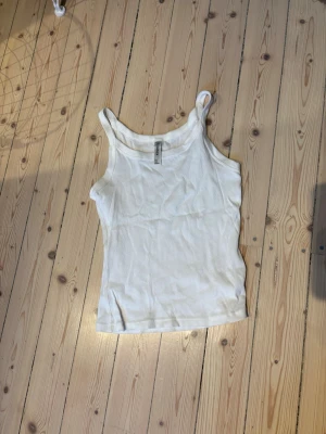 Vit ribbad pyamastop  - Säljer en vit ribbad pyamastopfrån Lindex  i storlek S. Toppen har klassisk ärmlös design med breda axelband och rundad halsringning i ett luftigt material som gör den bekväm att sova i. 