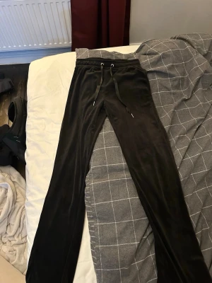 Svarta mjukisbyxor - Säljer ett par svarta mjukisbyxor i mjukt material med dragsko i midjan. Byxorna har raka ben och en relaxed passform, perfekta för chill dagar hemma eller när du vill vara bekväm. Klassisk look med enkel design och långa ben.